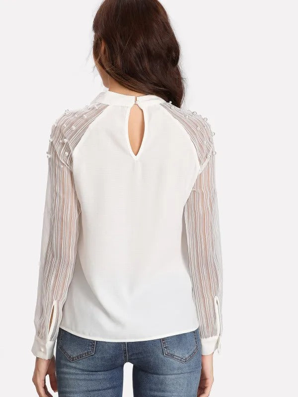 Blouse blanche à manches longues avec col lavallière et manches transparentes